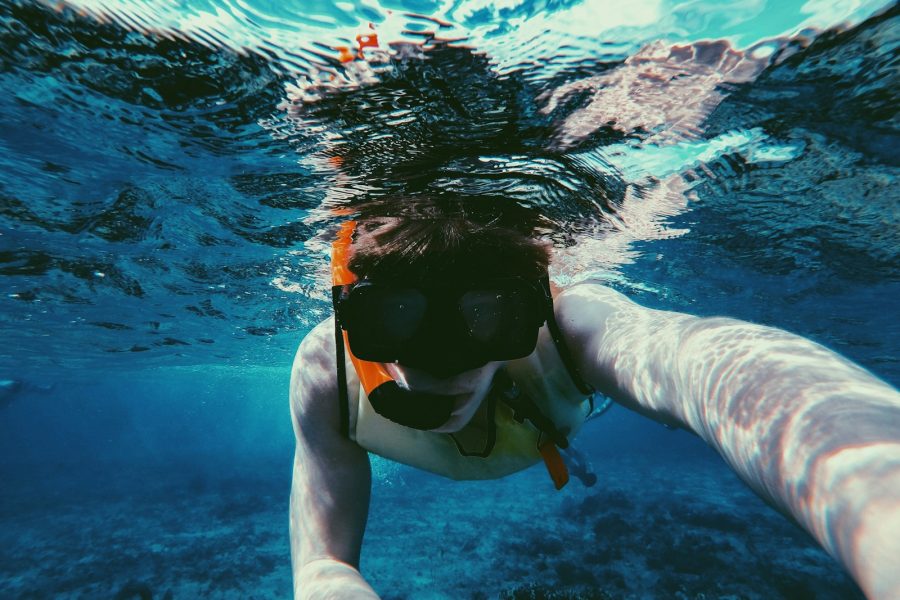 underwater photo of person wearing diving goggles and snorkel