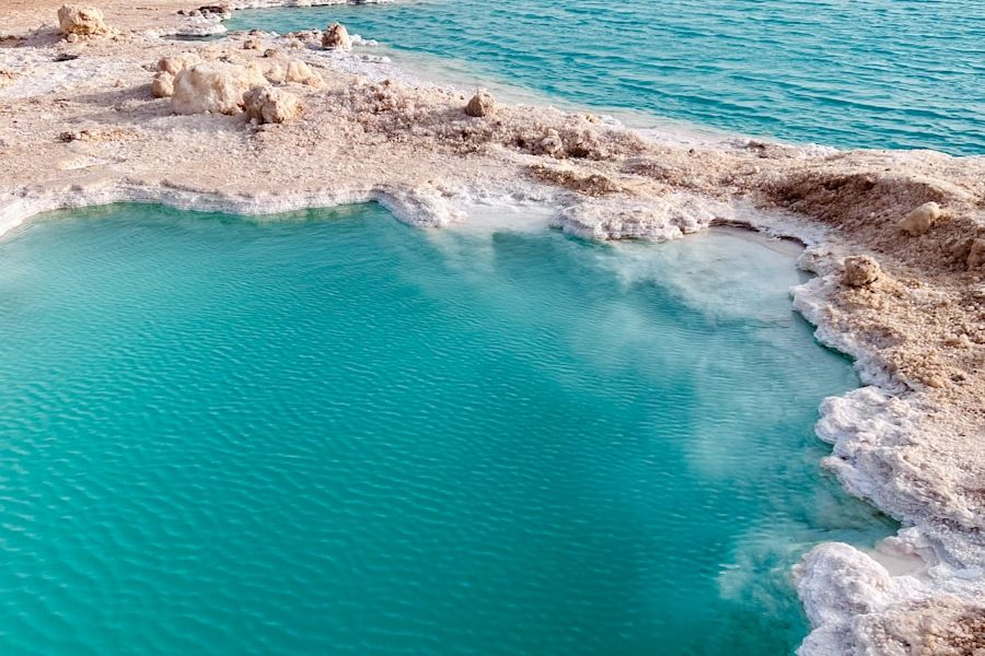 a body of water with rocks and a beach in the background
