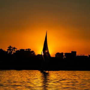 a sailboat in the water at sunset
