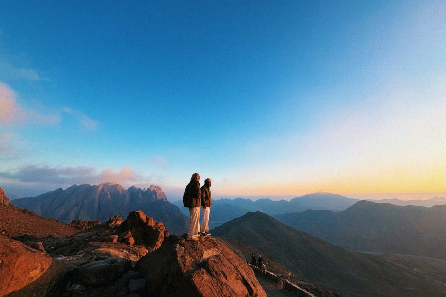 a couple of people standing on top of a mountain